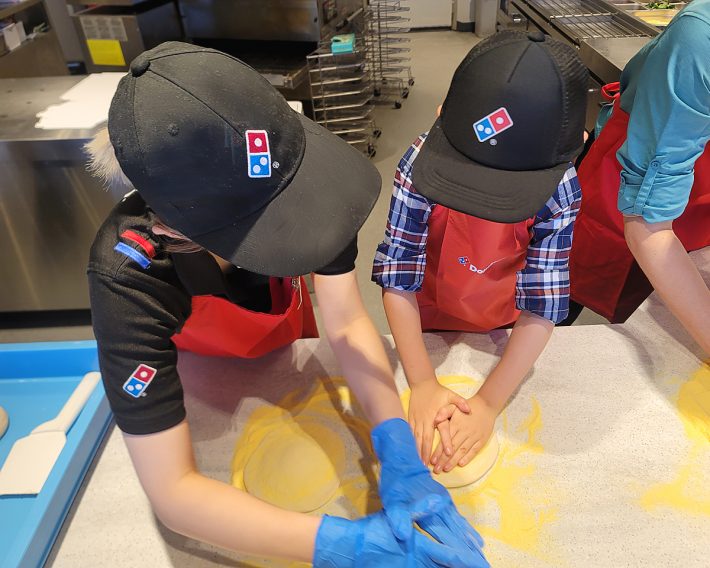 発酵したピザ生地を手で伸ばす工程を習っています