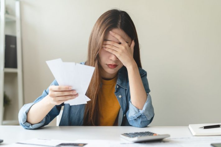 レシートを見て落ち込む女性