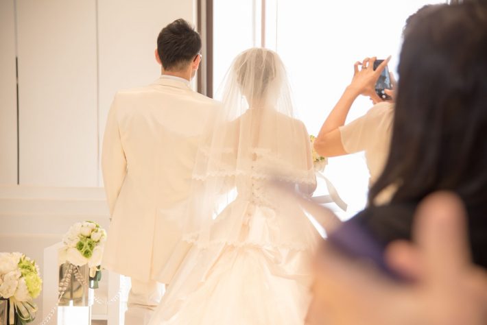 結婚式の新郎新婦と参列者