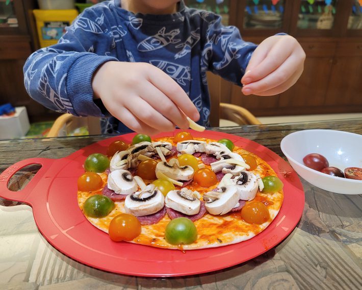 ピザの具を並べる息子