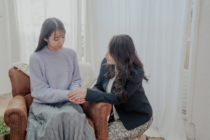 不安そうな女性と寄り添う女性