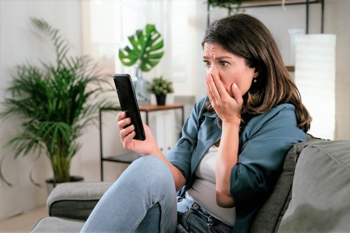 スマホを見て驚く女性