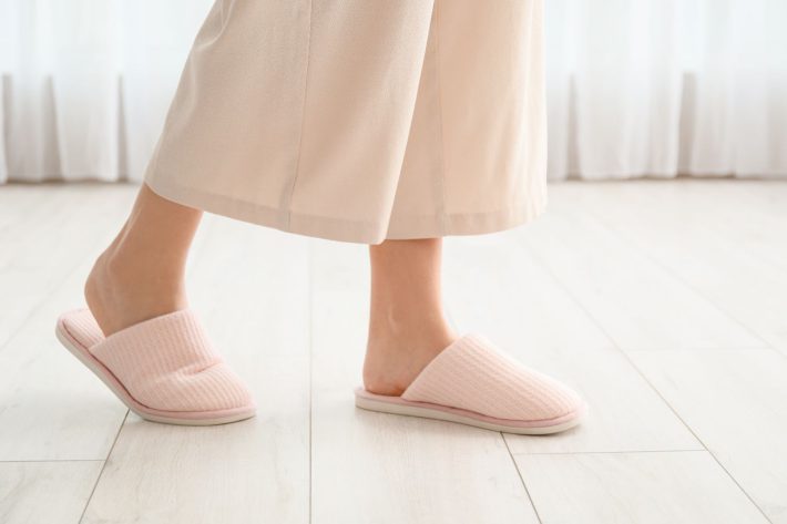 室内でスリッパをはく女性の足
