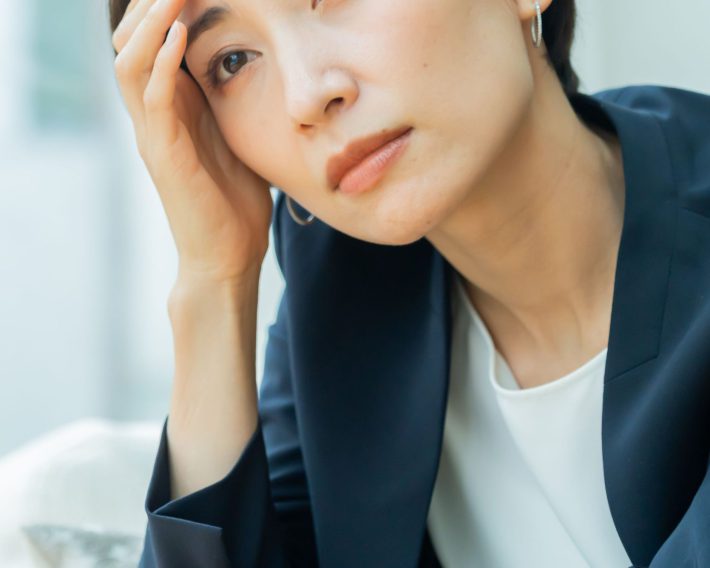 頭を抱えて悩む女性