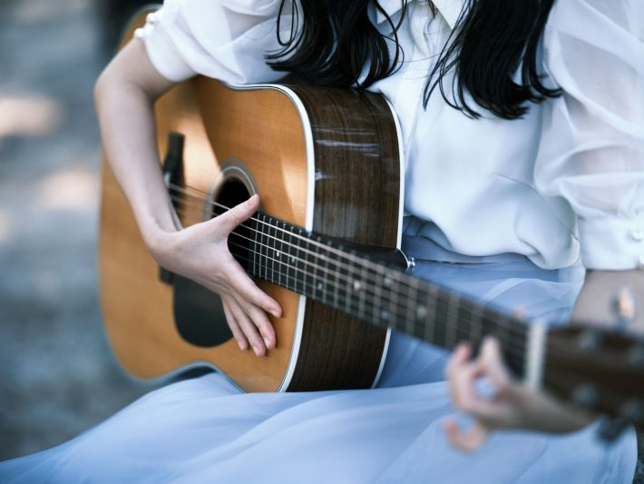 アコースティックギター　楽器弾く女性