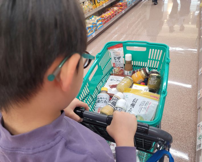 自分で選んだものをカゴに入れている息子