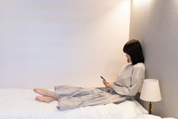 部屋でスマートフォンを使う女性