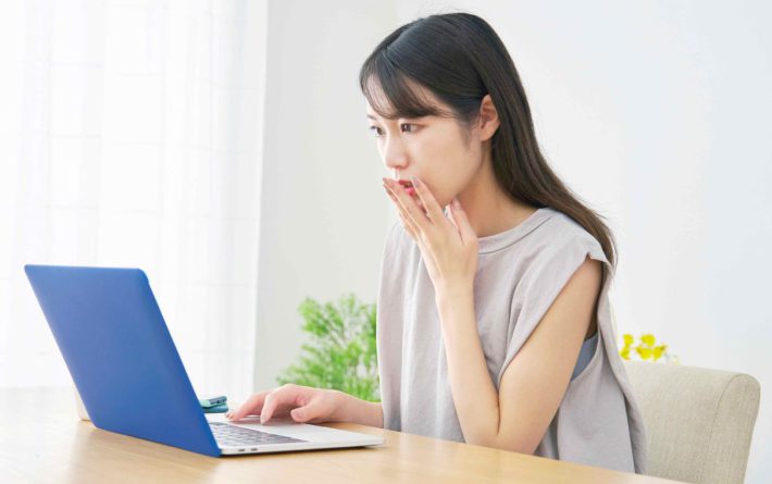 パソコンを見て驚く女性