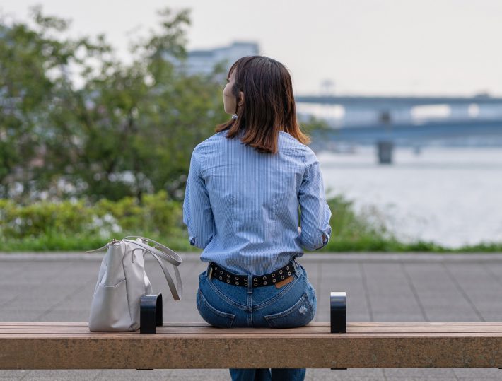 ベンチに座る女性の後ろ姿