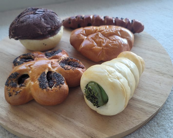 （左上から時計回りに）ショコラティエのカレーパン453円、ショコラステッキ540円、カカオフルーツのクリームパン378円、コロネ（抹茶）453円、あん・ドゥ・ショコラ378円