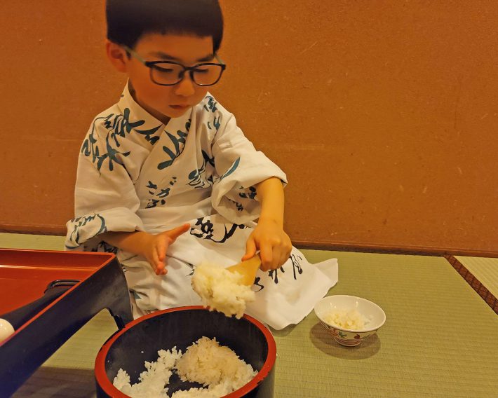 温泉旅館でごはんを自分でよそっています