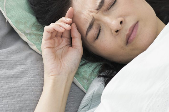 ベッドで寝るミドル女性