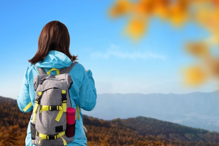 山から景色を眺める女性