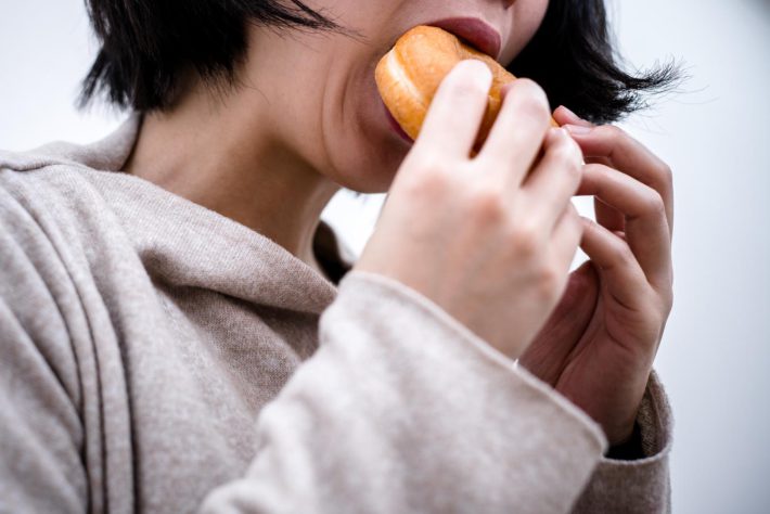 ドーナツを食べる女性
