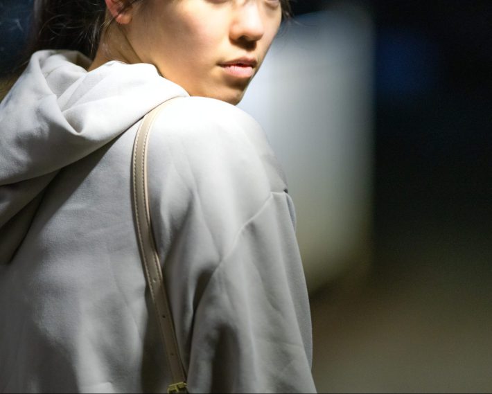 夜道で怯えて振り返る女性