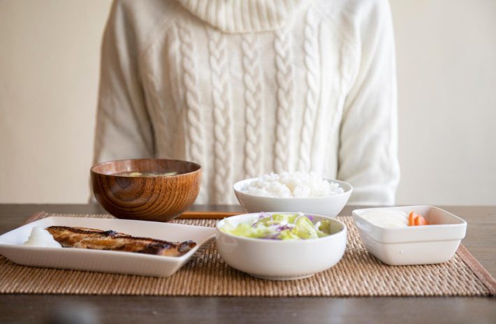 食事中の女性と食卓に並べられた料理