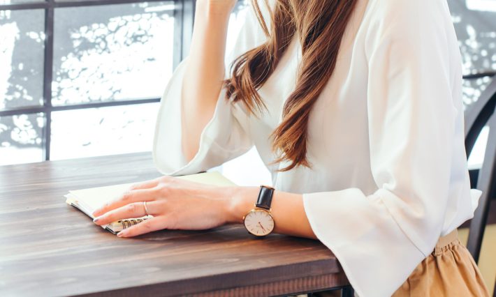 カフェでノートを開く女性