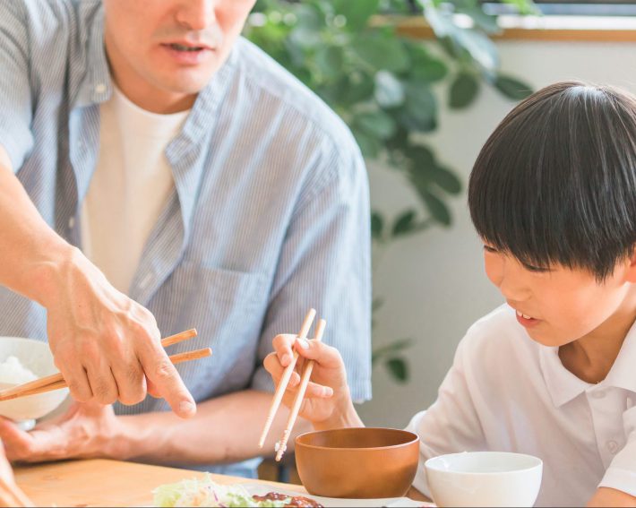食事中に子どもを注意する父親