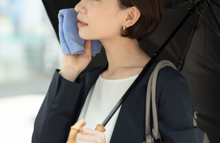 ハンカチで汗を拭く女性