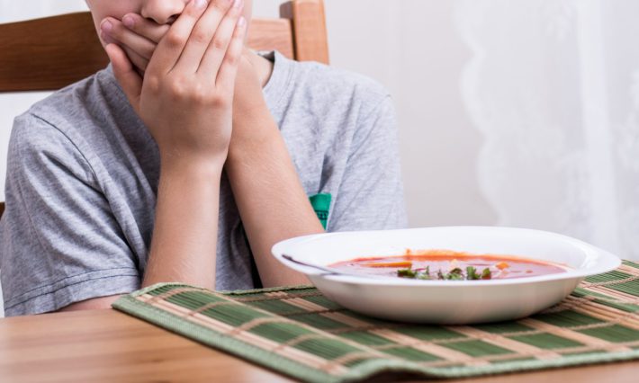 口をおさえる男の子