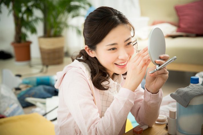 汚部屋で身支度をする女性