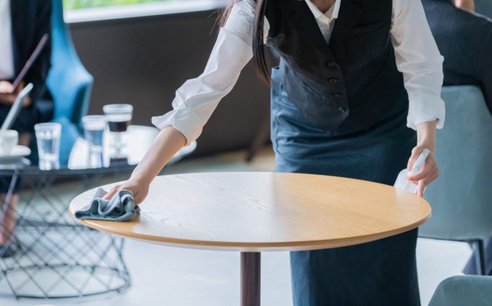 テーブルを拭くウェイトレス