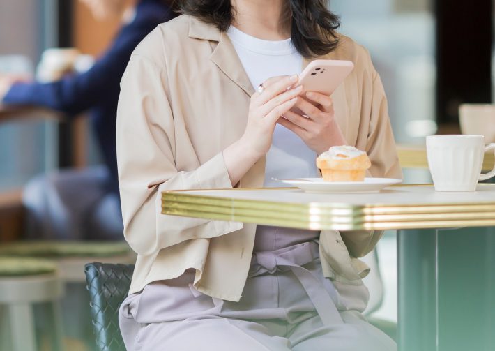 カフェでスマホを見る若い女性