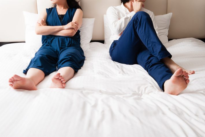 ベッドの上で喧嘩をしている男女カップル