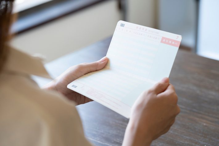 通帳を持つ女性の手元