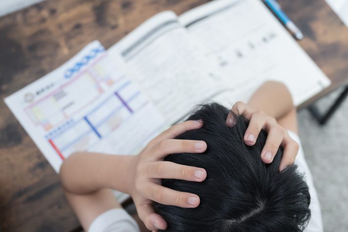勉強の成績が下がって頭を抱える子ども
