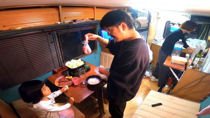 キャンピングカーの車内で食事の準備をする様子
