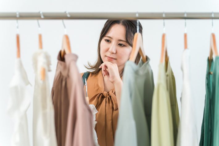 クローゼットの洋服を選ぶ女性