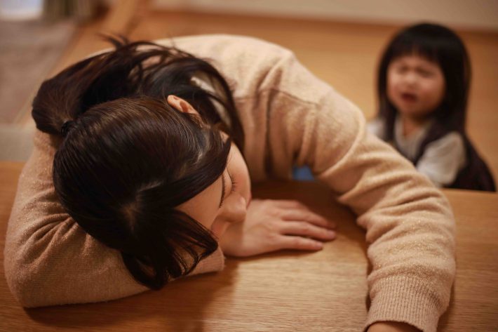 育児に疲れ居眠りする母親