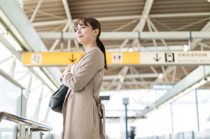 駅のホームに立つ女性