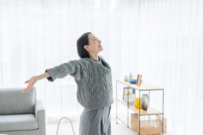 笑顔で伸びをする女性