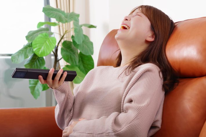 テレビを見ながら笑う女性