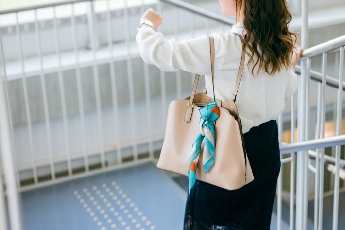 時計を見ながら移動する女性