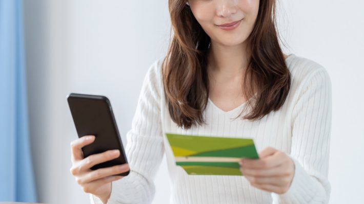 スマートフォンで銀行口座を確認する女性