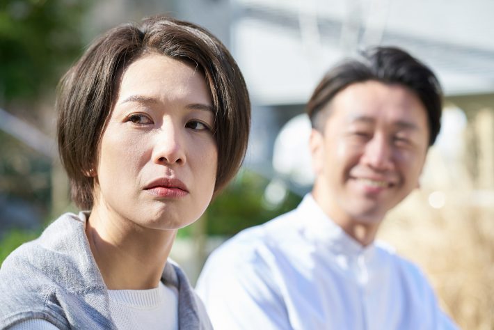 男性の隣で不機嫌な表情をする女性