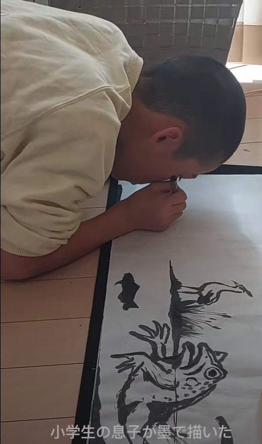 カエルと鳥の絵を墨で描く息子さん