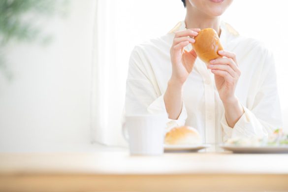 朝食にパンを食べる女性