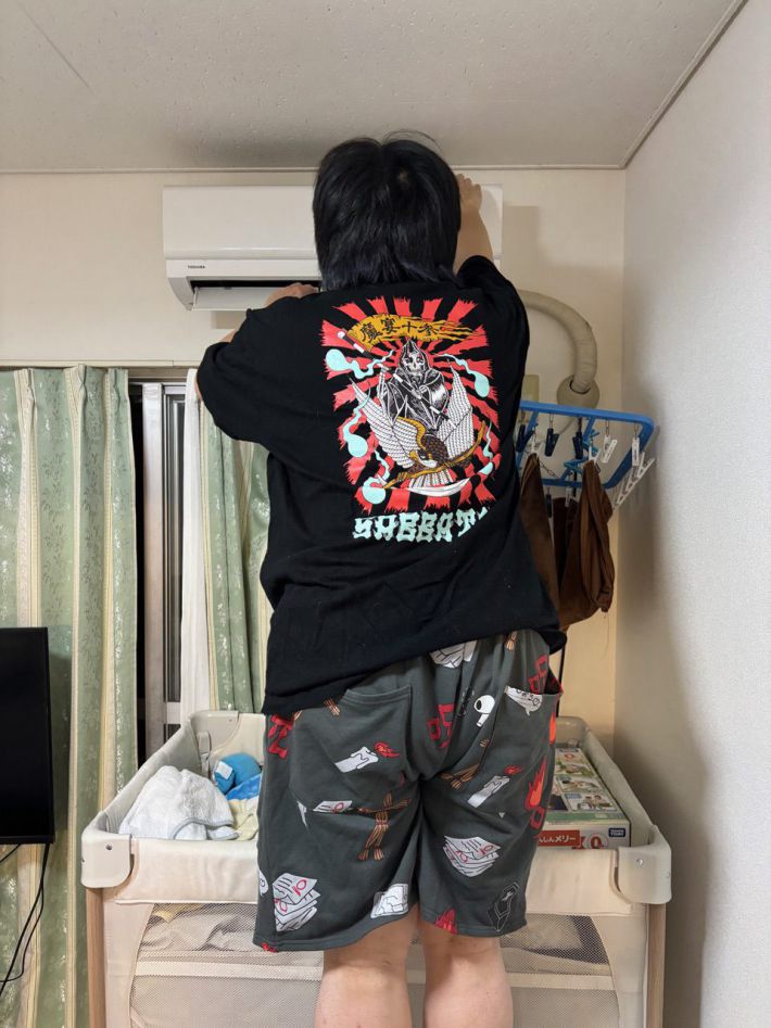 エアコンの掃除をする夫