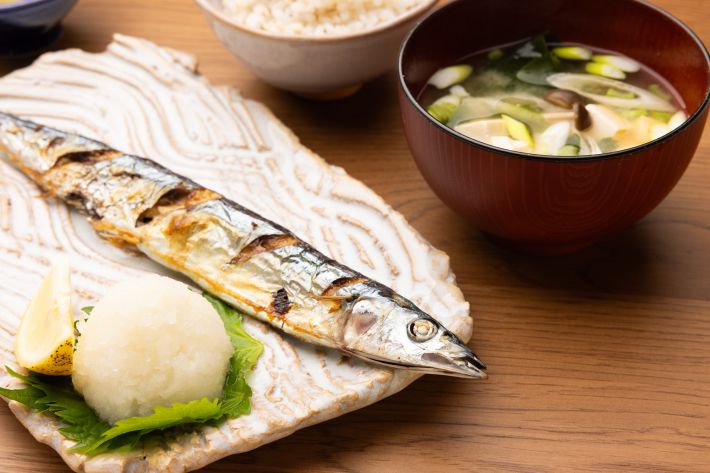 木製のテーブルに置かれた焼きサンマ