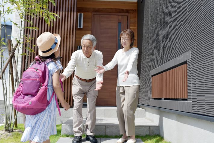 帰宅した孫娘を出迎えるシニア夫婦