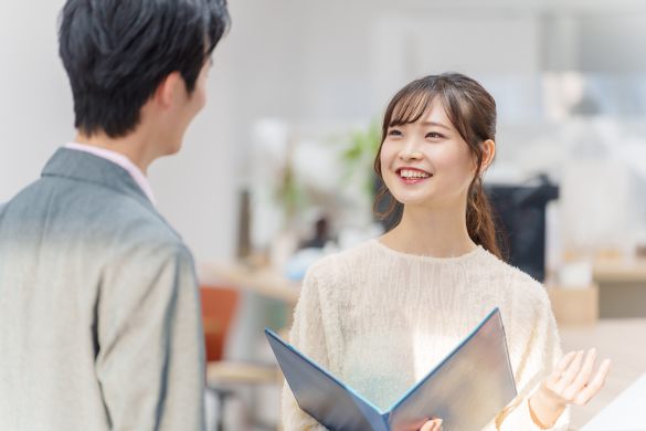 オフィスで立ち話をする若い男女