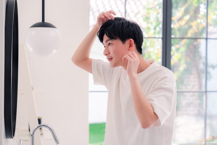 洗面所で身だしなみを整える男性