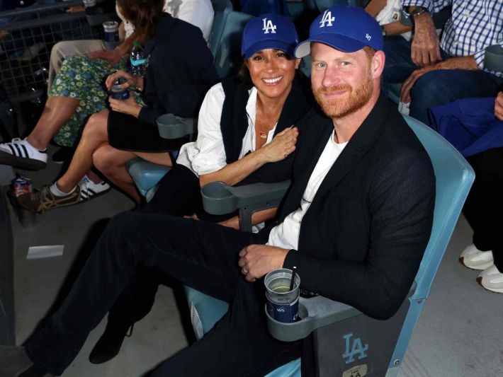 ドジャースの帽子をかぶってワールドシリーズを観戦するヘンリー王子とメーガン妃