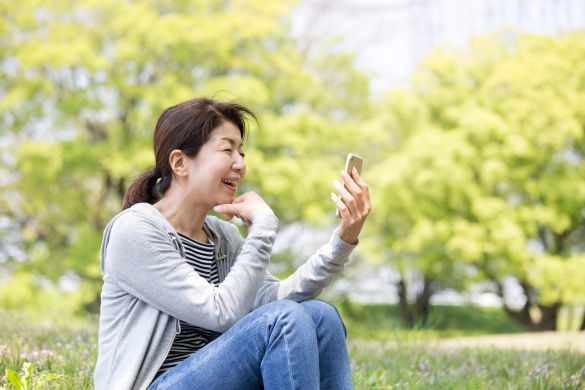 スマホを眺めるミドル女性