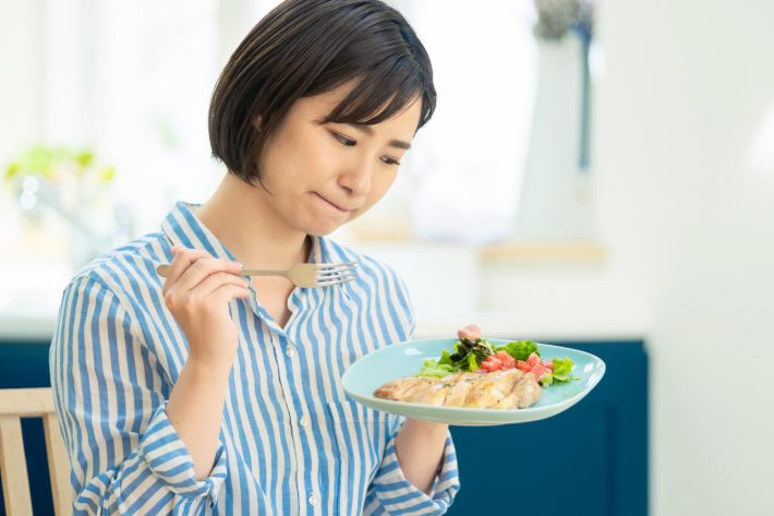 食事しながら悩む女性