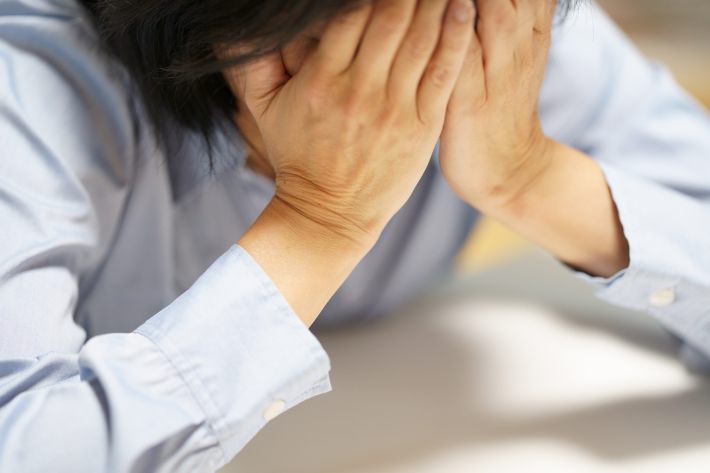 手で顔を覆う女性